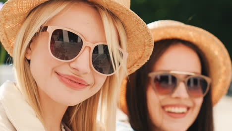 dos mujeres felices con sombreros y gafas de sol