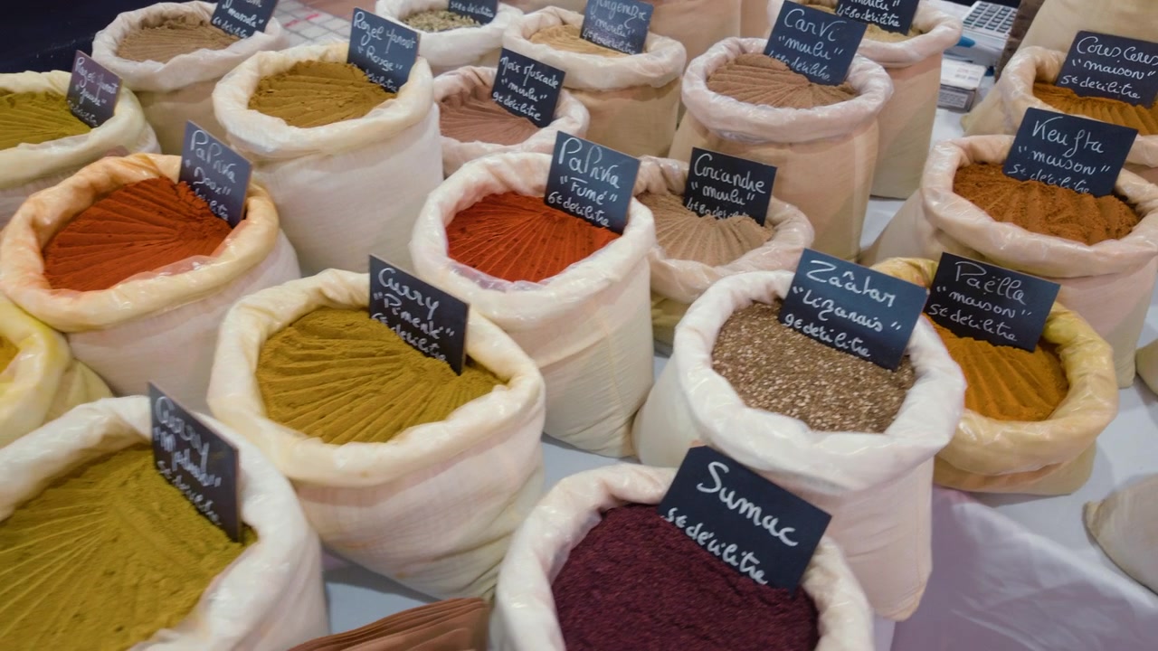 Close view of bags of herb and spice blends with handwritten French labels at a market stall, Cannes, France