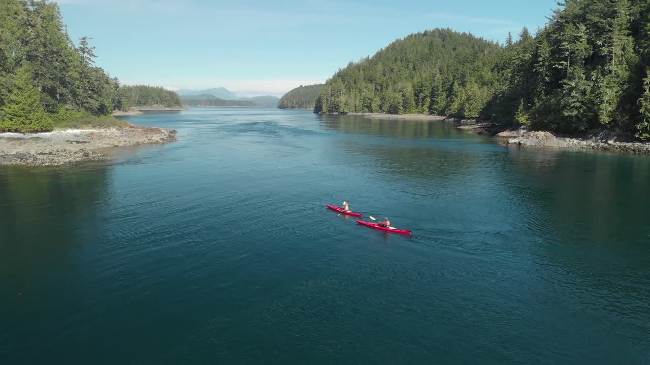 Aerial shot of two red kayaks paddling in the ocean