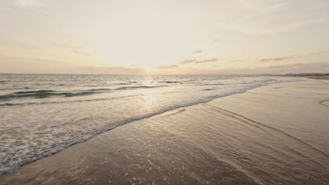 Sandy-Portugal-coastline-during-sunset,-aerial-drone-low-altitude-view