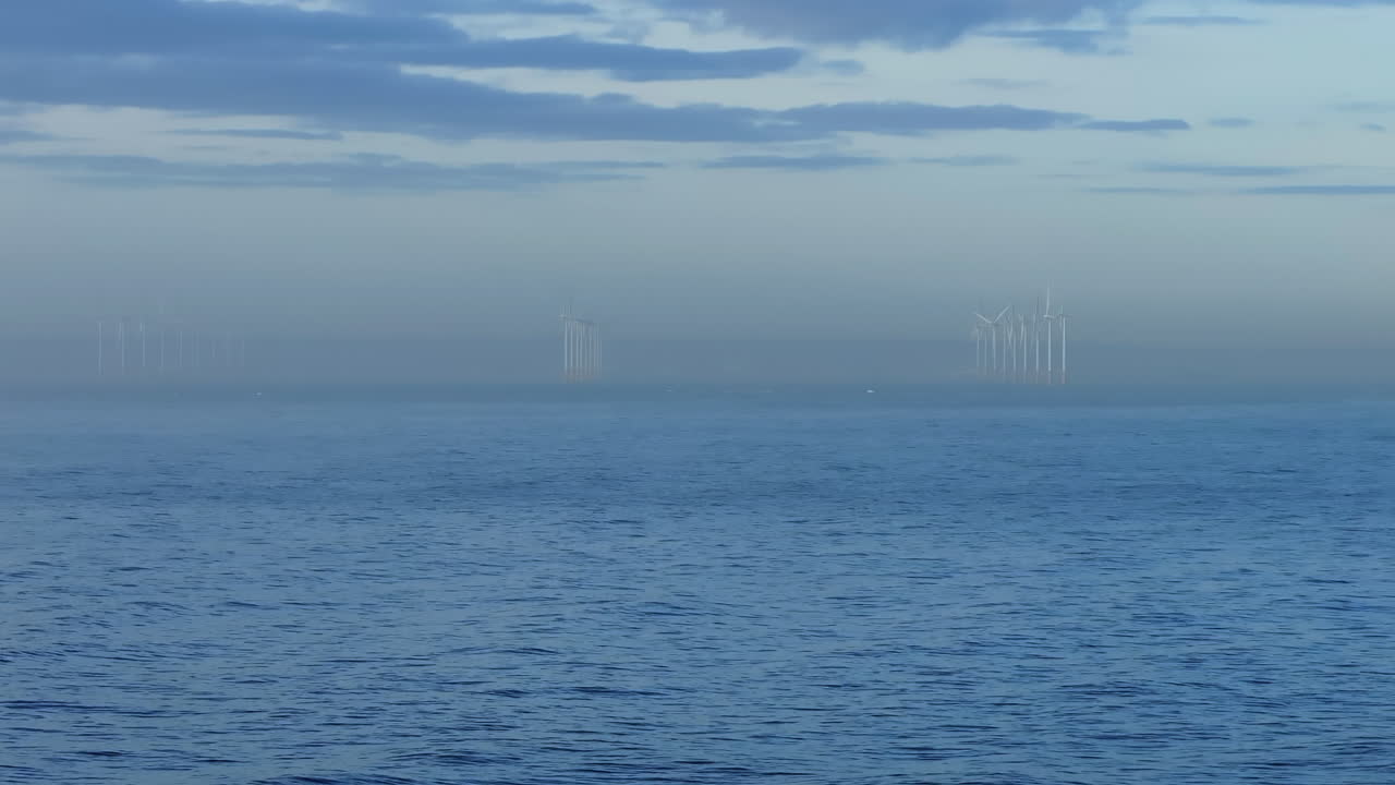 멀리 바람 터빈 농장과 함께 바다 위에서  드론을 설정