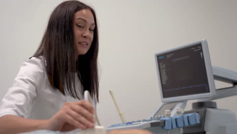 retrato de una doctora haciendo ultrasonido y hablando con un paciente