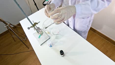 a scientist conducts a chemical reaction between copper carbonate and sulfuric acid in a laboratory setting