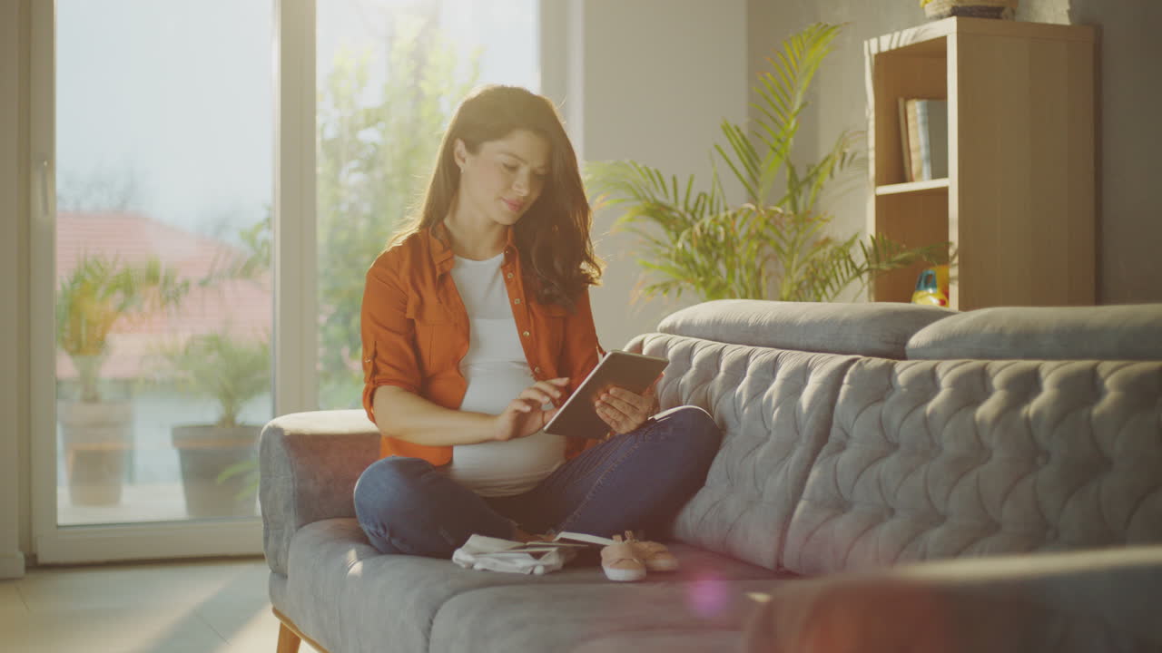 가정에서 태블릿을 사용하는 임신한 여성