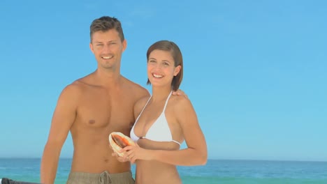beautiful smiling couple posing with a shell