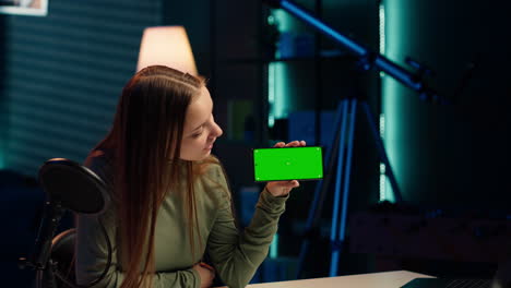 los expertos en tecnología sonrientes revisan el modelo de teléfono inteligente de pantalla verde recién lanzado