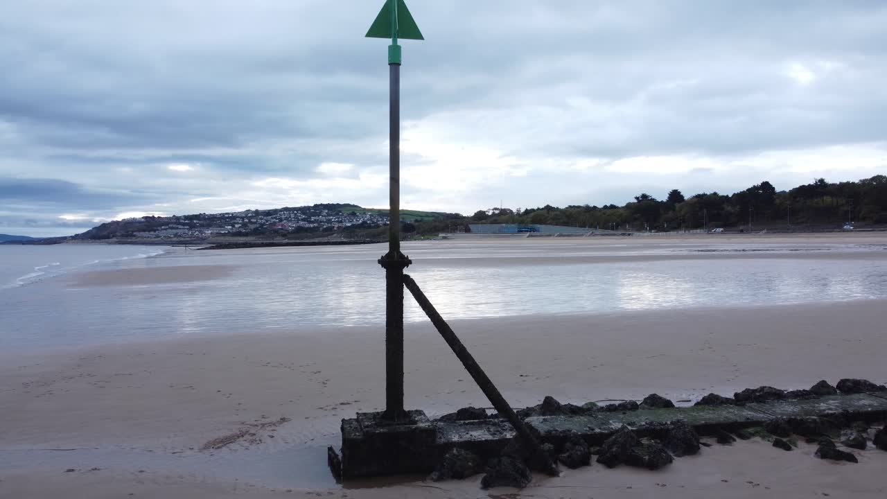 marcador de mareas costeras vista aérea bajo lento aumento por encima de moody nublado marea baja playa costera