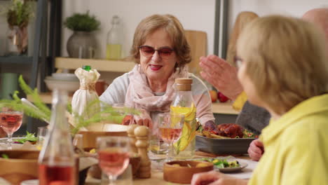 Mujeres-Mayores-Charlando-Con-Amigos-En-Una-Cena-En-Casa