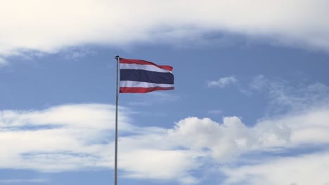 A-view-from-a-distance-of-the-National-flag-of-Thailand-as-it-is-waving-in-the-air-against-the-cloudy-blue-skies-in-Thailand