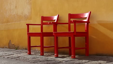 two red chairs against a yellow wall