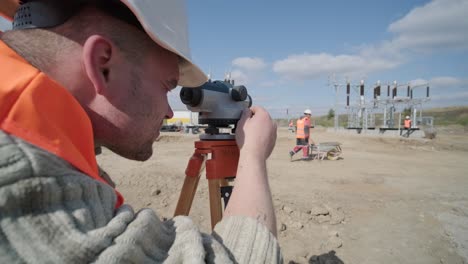 an engineer surveyor takes measurements at the construction of a transformer substation