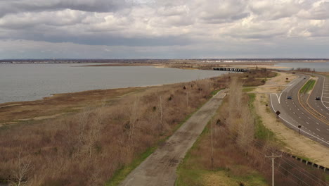 una vista aérea de un dron en un día nublado, sobre un camino de tierra que está cerca de una bahía