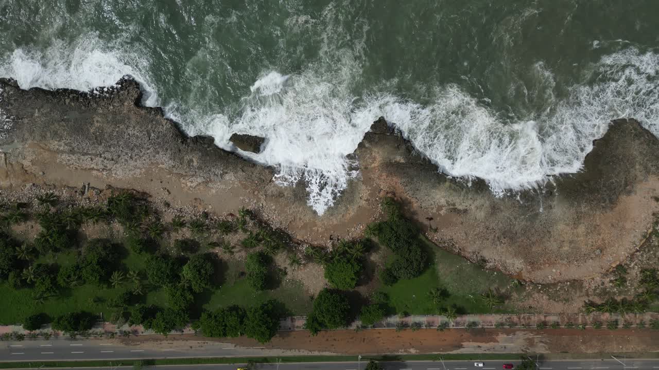 vista aérea de arriba hacia abajo de las olas del océano chocando contra la costa rocosa