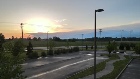 Rising-up,-revealing-a-vehicle-driving-by-and-a-beautiful-sunset