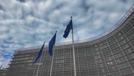 slow motion of eu flags waving strongly outside commission headquarters