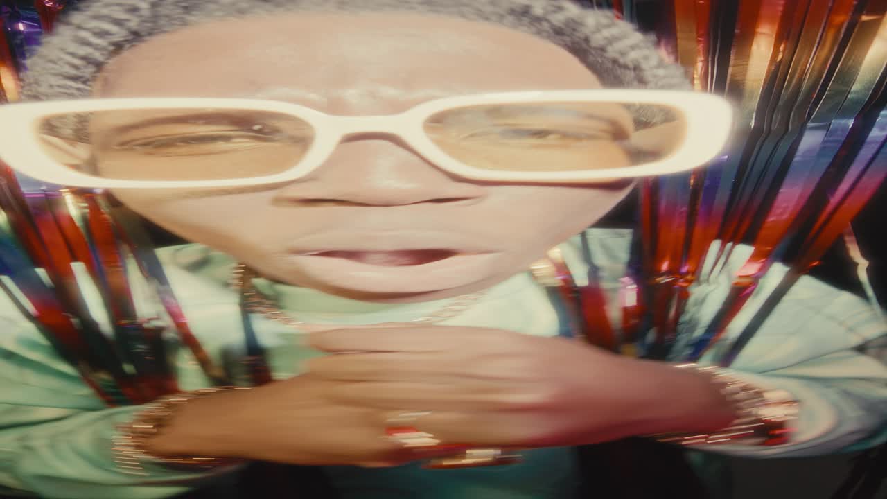 Black Hip-Hop Musician Performing Rap Song behind Tinsel Curtains