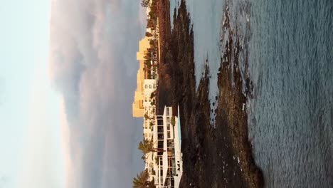 Vertikaler-Drohnenschuss-Strand-Von-Lanzarote-Mit-Haus-Am-Ufer