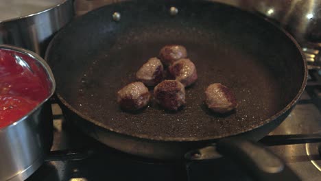 Slow-motion-pull-out-shot-of-a-batch-of-meatballs-being-cooked