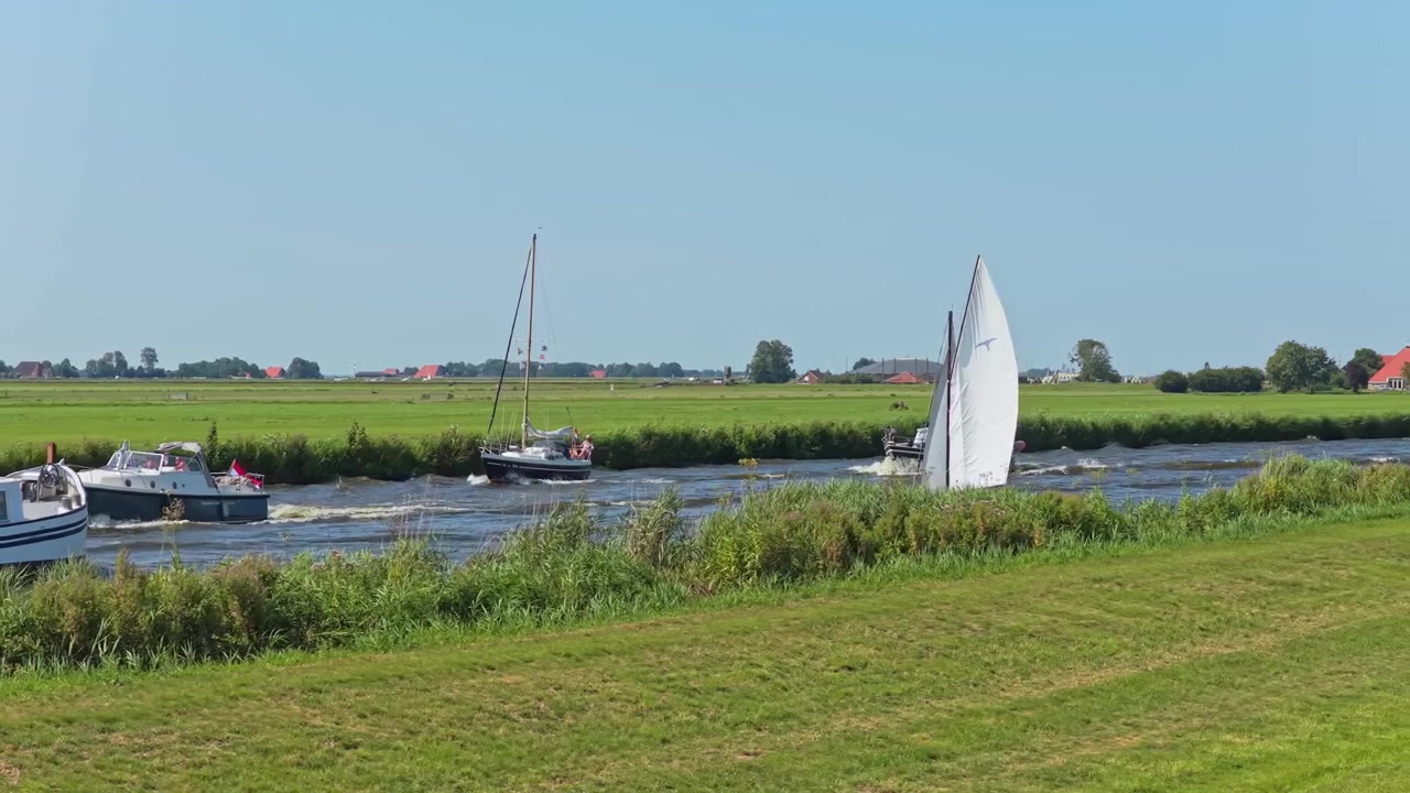 Boats Sailing Along a Scenic Canal in the Dutch Countryside