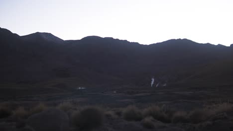 Sehr-Weit-Entfernter-Geysir-Auf-Einem-Berg-In-Der-Wüste,-Morgenweite-Aufnahme