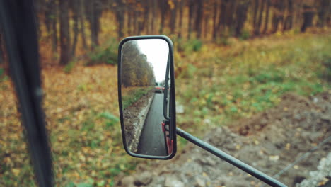 sideview of road roller mirror. looking at the construction site in the rear view mirror