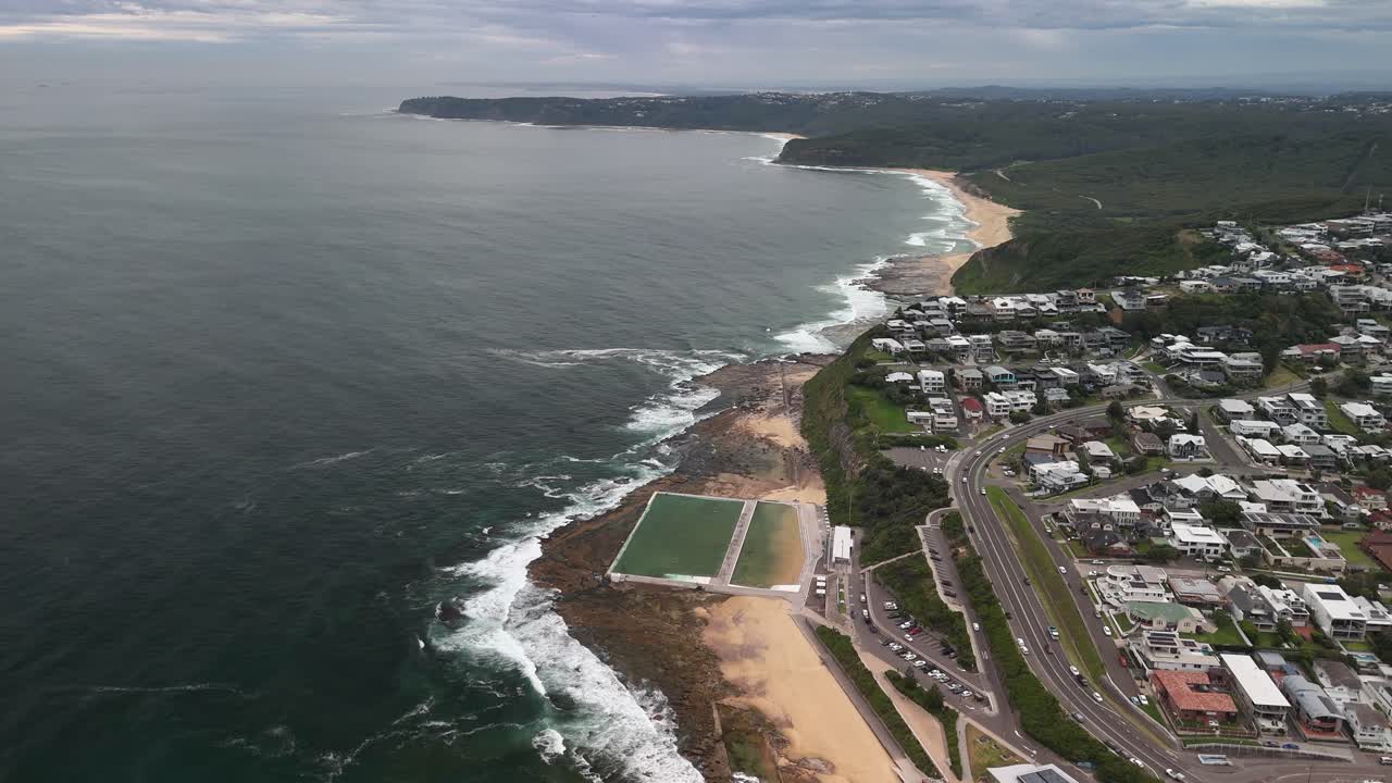 Grey overcast aerial view of Mereweather pools on beach, NSW Australia