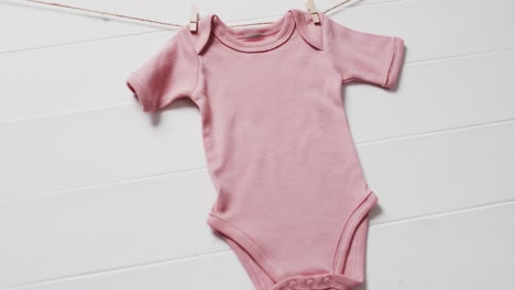 Video-Eines-Rosafarbenen-Babys,-Das-An-Kleidern-Hängt-Und-Online-Mit-Kopierraum-Auf-Weißem-Hintergrund-Bettelt