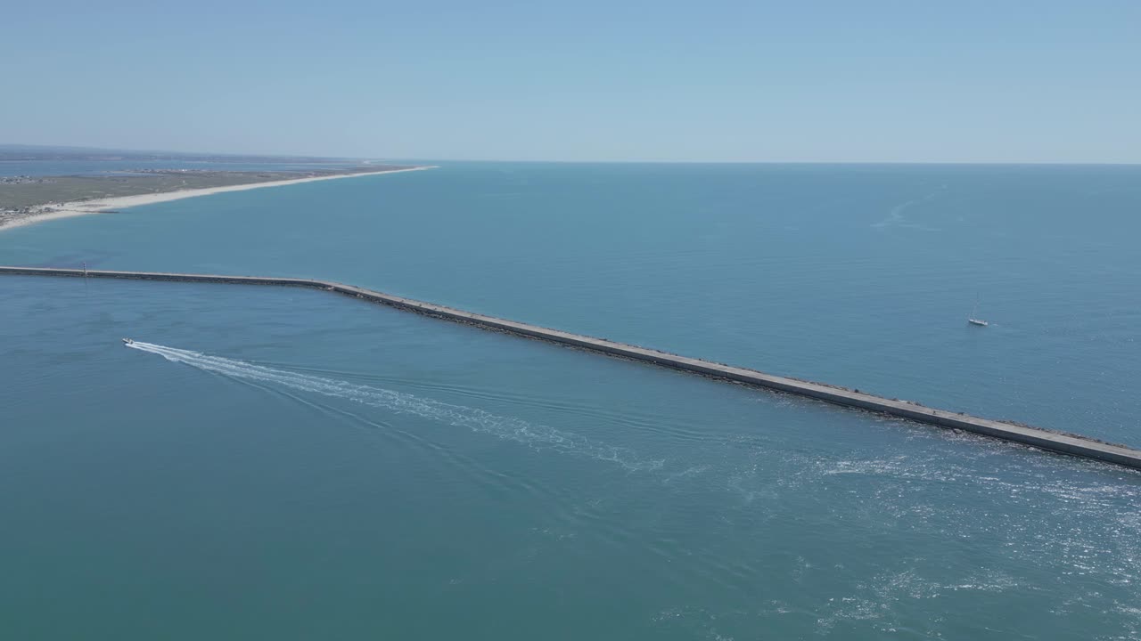 воздушный вид лодки, движущейся к пляжу фарол в спокойных водах алгарве в фантастический солнечный день