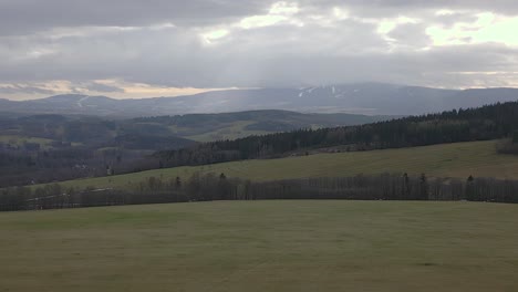 aerial shot of mountainous landscape with wide pastures