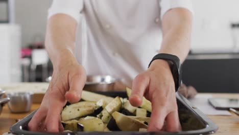 cocinera caucásica que enseña a un grupo diverso usando máscaras faciales