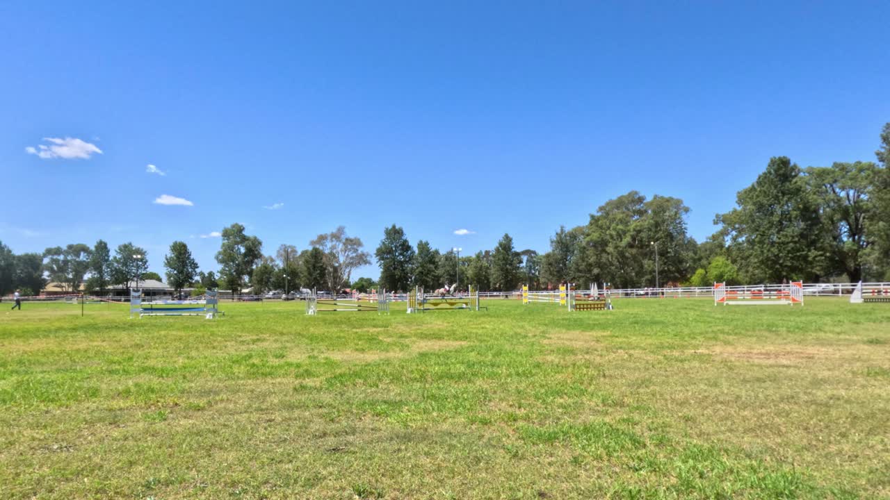 말 과 승마자 가 열린 풀 을 가로질러 이동 하고 있다