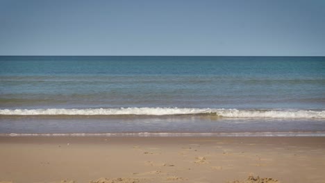 slow motion view of gentle waves rolling and breaking on a sandy beach. magdalen islands, quebec peaceful holiday scene.