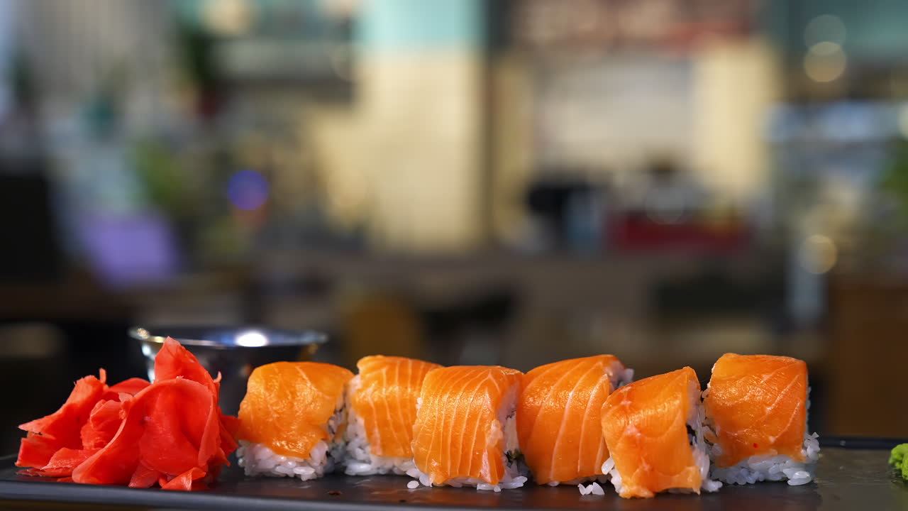 Salmon roll sushi with cheese. Tasty sushi with salmon on top. Set of japanese food on black tray. Seafood kitchen.