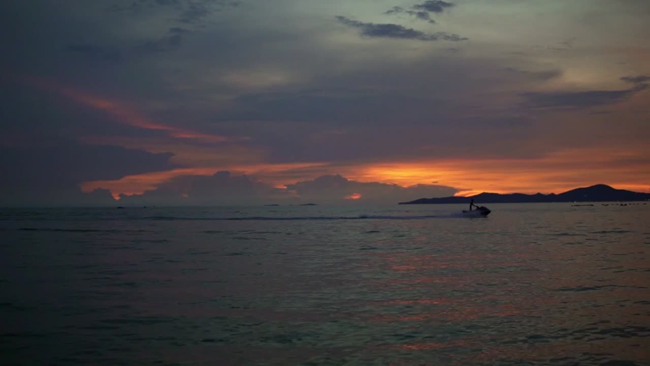 Silhouette Of A Lone Jet Ski Riding Across The Beautiful Twilight Sky In Pattaya Beach
