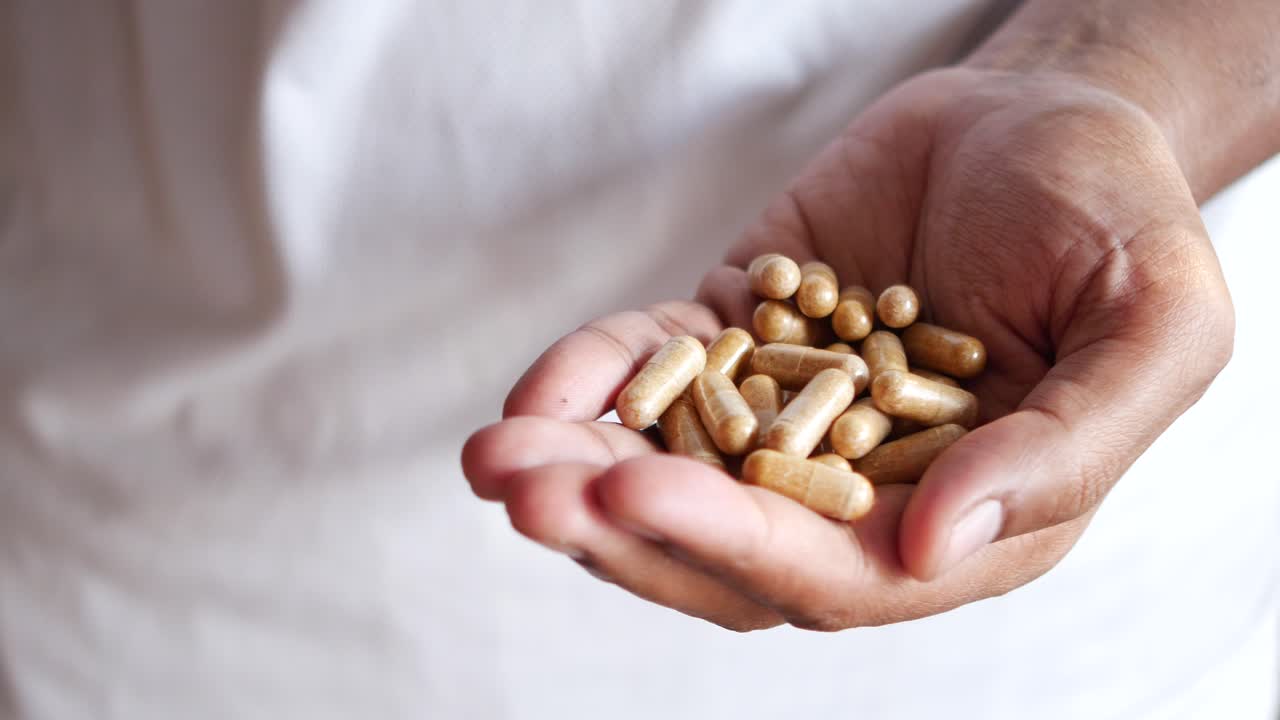 mano con una pila de cápsulas