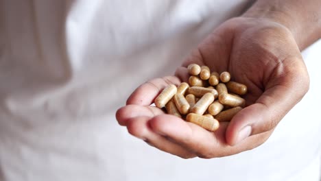 Hand holding a pile of capsules
