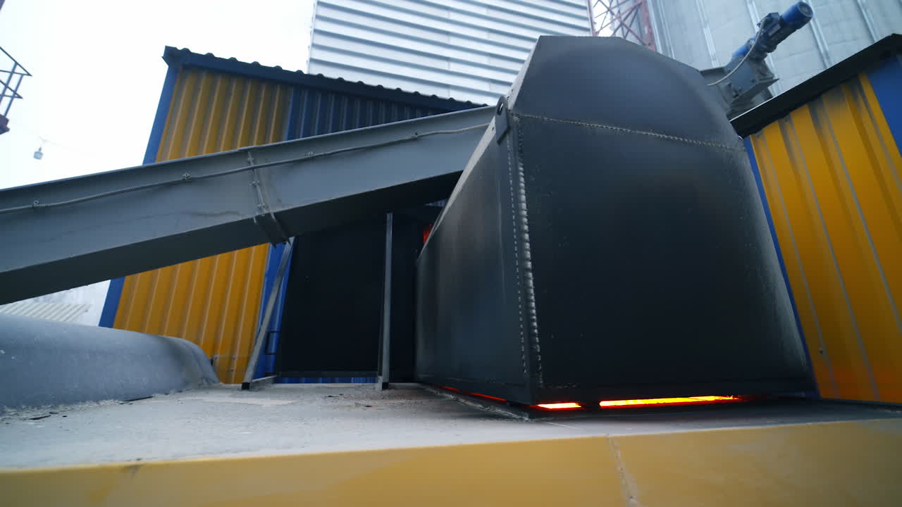 Huge hearth with burning fire inside. Flashes of fire seen in the gaps of the hearth. Furnace place among the granary industrial premises.