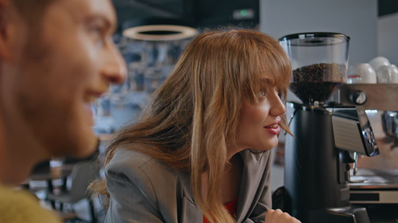 Cheerful girl enjoying coffee break at bar counter closeup. Colleagues talking