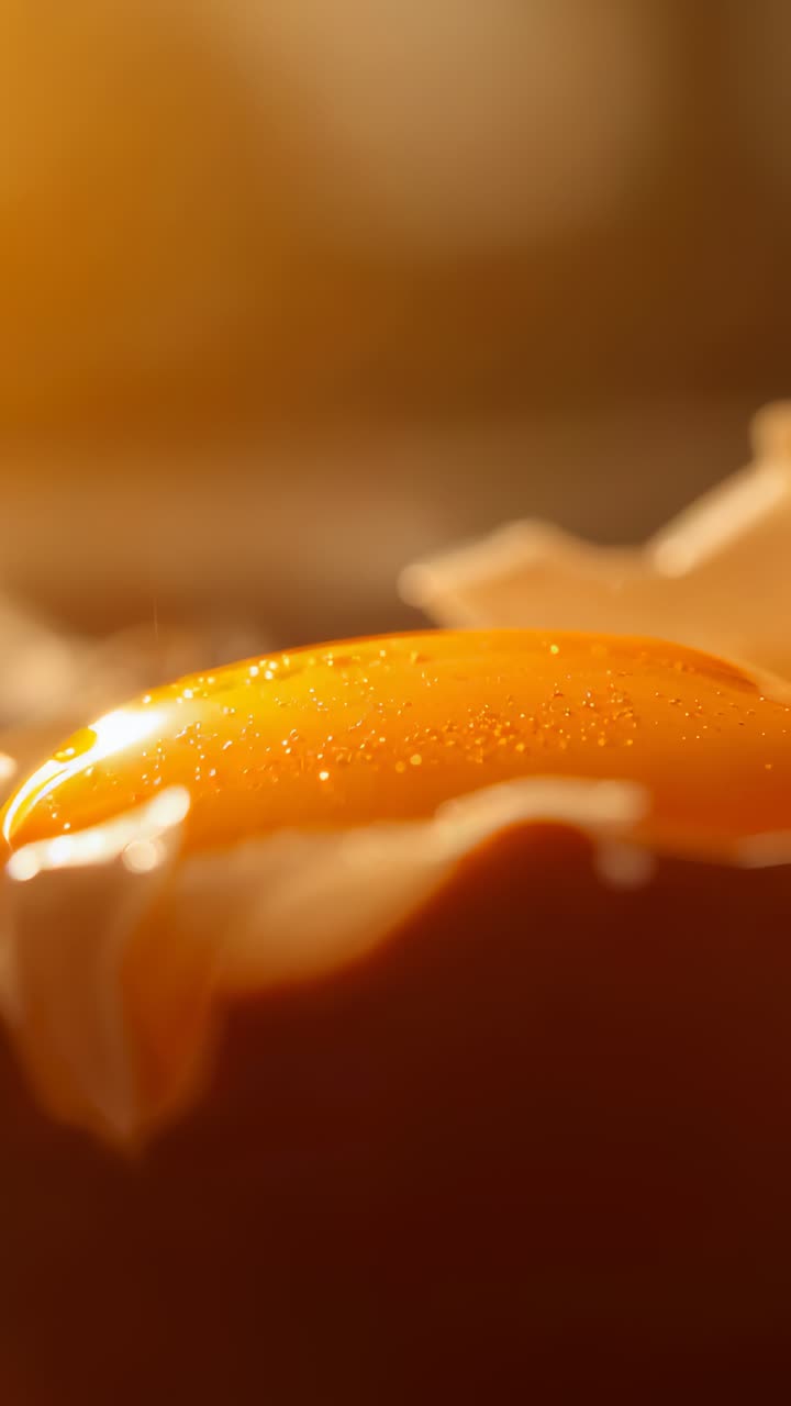 Vertical video: Shaker tipping sending seasoning drifting over intact yolk in pan, shells shining