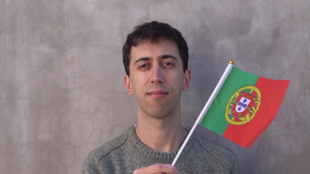 Vuxen man viftar med Portugals flagga. Slow motion. Närbild.