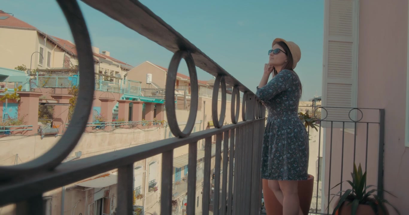 Una giovane donna in piedi sul balcone