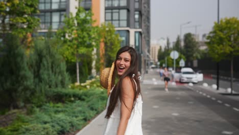 young woman wearing a straw hat in a city street