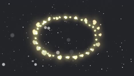 animation of circle of glowing heart christmas fairy lights over falling snow, on black