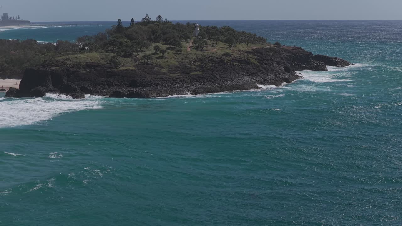 Faro di Fingal Head, promontorio e strada rialzata con onde che si infrangono nel Nuovo Galles del Sud, Australia. Ripresa aerea circolare con drone