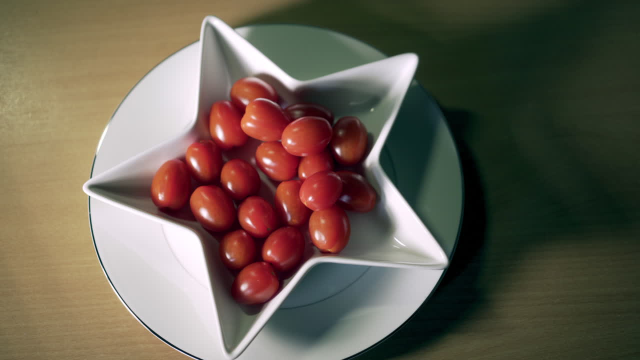 화이트 스타 접시에 아기 매실 토마토 여성의 손이 섬세하게 하나를 가져