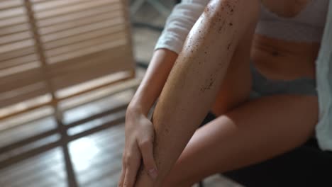 mujer aplicando exfoliante de café a sus piernas