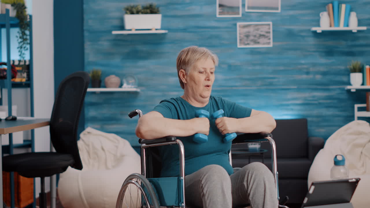 Aged woman stretching arms muscles with dumbbells