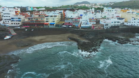 el puertillo, arucas, gran canaria: aerial view in orbit over the beach and the houses on the coast