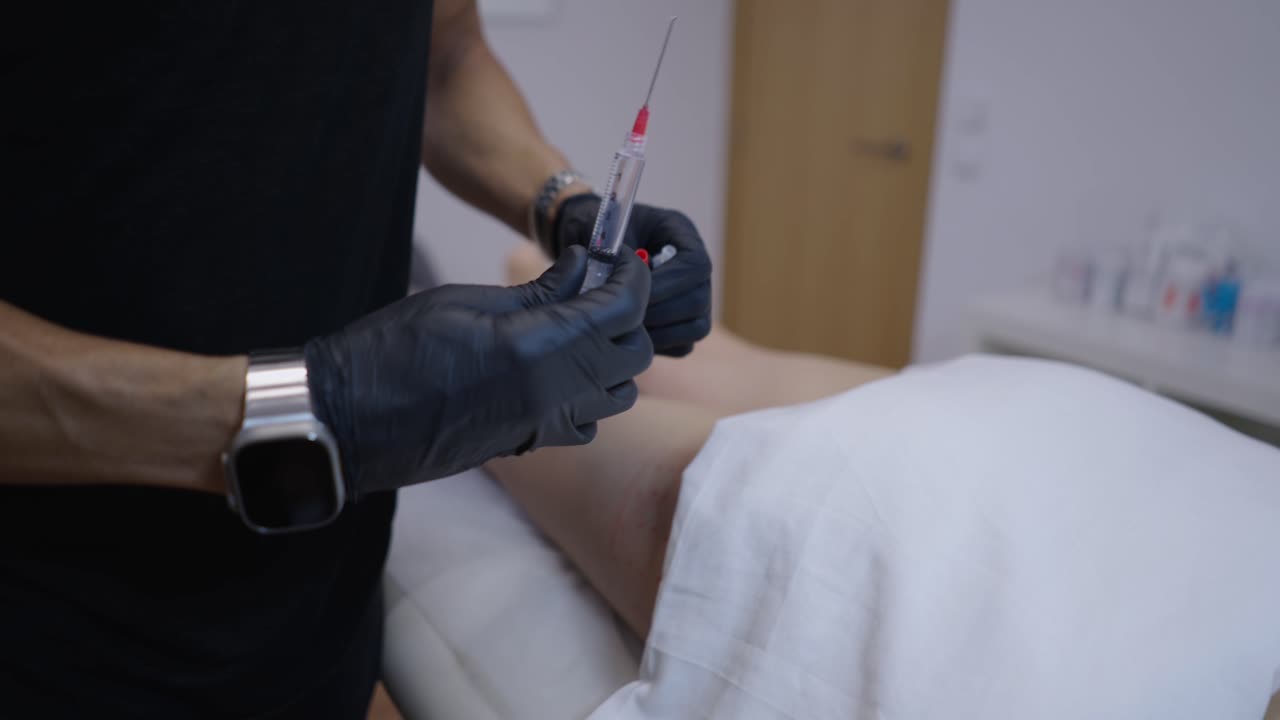 Medical professional preparing an injection on a patient's leg
