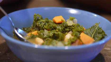 a spoon full of bowl of kale and white bean soup